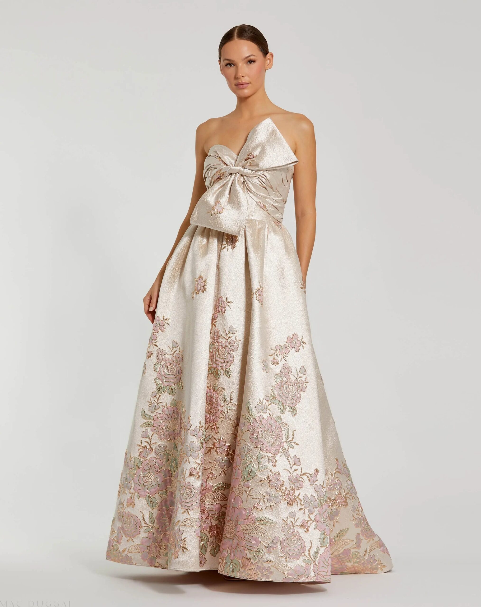 Strapless ball gown with brocade floral fabric and bow detail